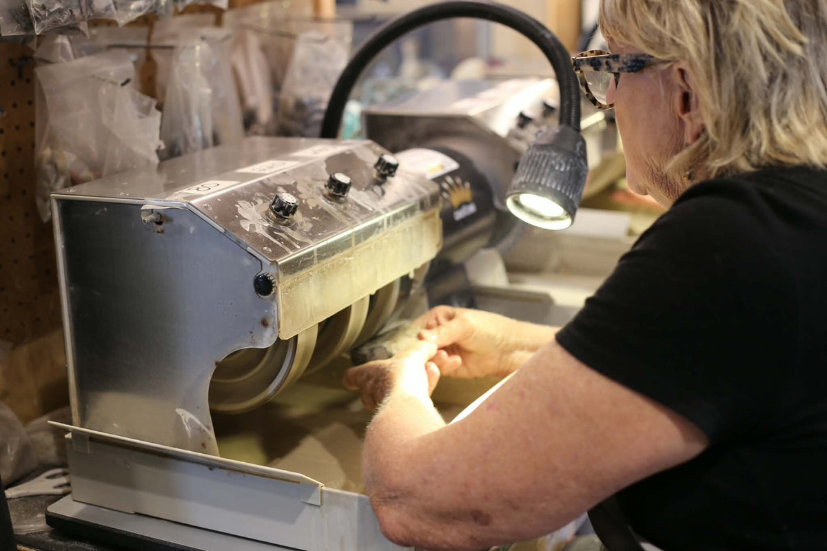 A participant polishing a stone at a cabbing machine inside the Trading Post