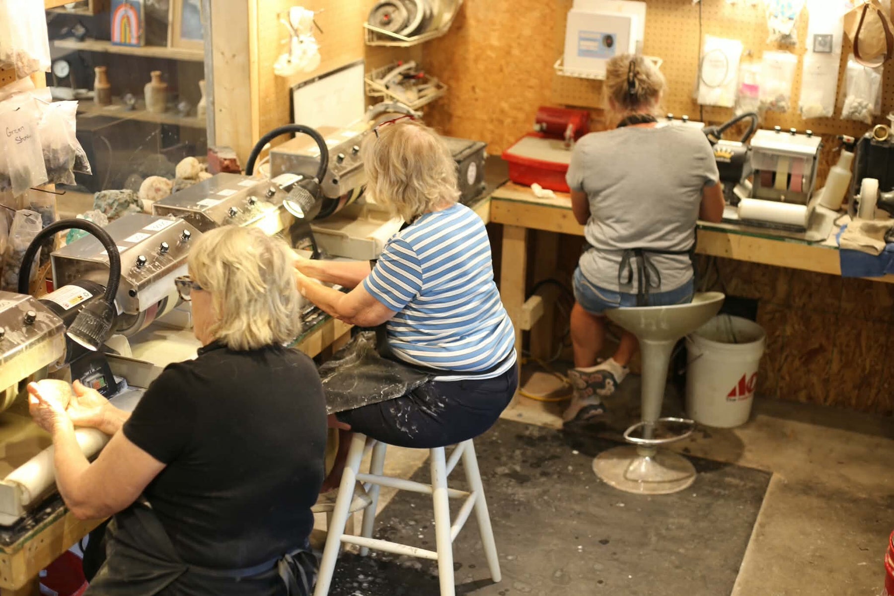 Three class participants working at polishing wheels in the Trading Post